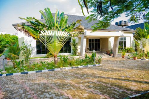 a house with a palm tree in front of it at Number Ten by Scarborough - Luxury Serviced Apartments, Asaba in Asaba