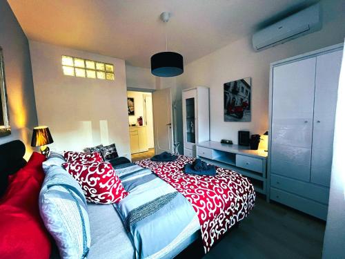 Un dormitorio con una cama grande con almohadas rojas y blancas. en Host Flora Sanremo, en San Remo