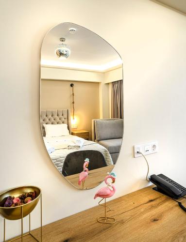 a mirror in a bedroom with a bed and pink flamingos at Anthidon Nature Estate & Farm in Chalkida