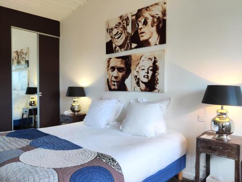 a bedroom with a bed and some pictures on the wall at Le Roc E Fiori Hotel - Teritoria in Porto-Vecchio