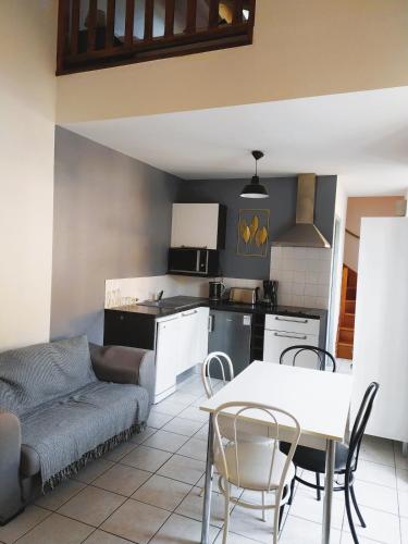 une cuisine et un salon avec une table et un canapé dans l'établissement L 'appart de la volane, à Vals-les-Bains