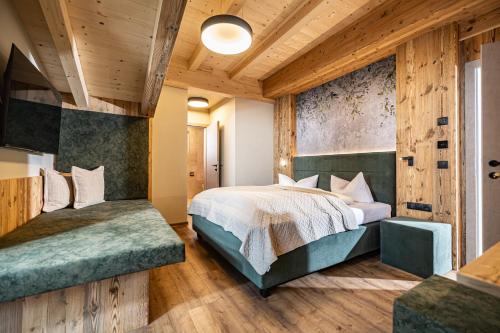 a bedroom with a large bed and a wooden wall at Studio 24 by Hotel Brücke in Mayrhofen