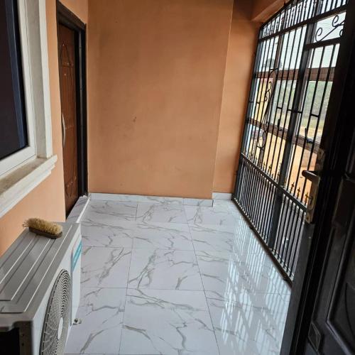 a hallway with a marble floor and a window at Hansville Apartment in Benin City