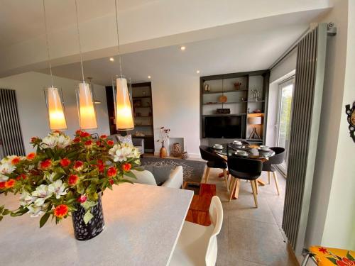 a kitchen and living room with a table with flowers at Rare & Breathtaking View With Secret Garden Bar in Horsforth