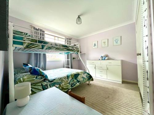Un dormitorio con dos literas y un escritorio. en Tuncurry tranquility PID -STRA - 59456, en Tuncurry