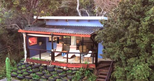 a blue house with a deck on top of a hill at Hadada Self Catering Studio in Haga-Haga