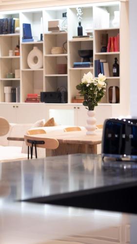 un salon avec une table avec un vase de fleurs dans l'établissement Villa de Luxe 18 Personnes avec Cinéma Privé, Spa, et Salle de Sport - Idéal Séjour Bien-Être, à Gif-sur-Yvette