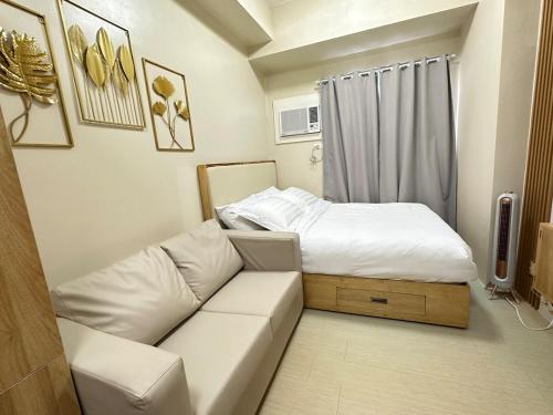 a living room with a couch and a bed at H&A Cozy Stays Iloilo in Iloilo City