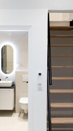 une salle de bain avec toilettes et lavabo dans l'établissement Villa de Luxe 18 Personnes avec Cinéma Privé, Spa, et Salle de Sport - Idéal Séjour Bien-Être, à Gif-sur-Yvette