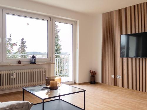 a living room with a glass table and a tv at Wohnen bei Franzi - Tolle Wohnung für 4 Personen in Altötting
