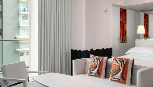 a bedroom with a bed and a table and chairs at Dua Miami, Autograph Collection in Miami