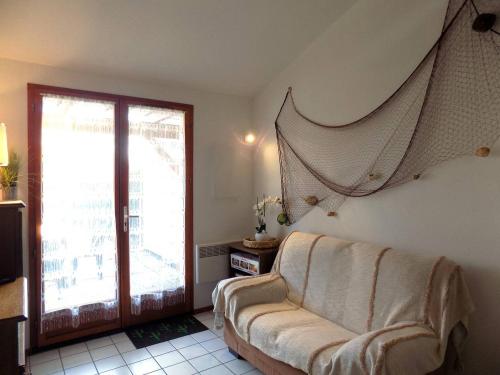 un salon avec un canapé et une fenêtre dans l'établissement Saint Palais sur Mer - VILLA MITOYENNE de VACANCES - résidence BOIS SOLEIL, à Puyraveau