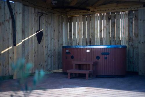 a bench in a room with a wooden wall at Burtree Country House, Tipi's, Treehouse & Lodge & house rooms with hot tubs in a private garden in Thirsk