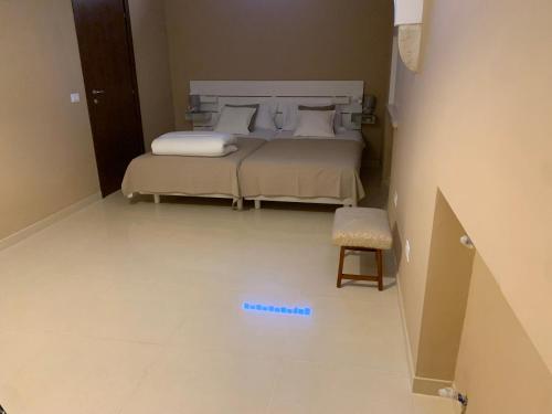 a bedroom with two beds and a stool in a room at oasi di pace fasano BIS in Fasano