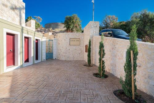 a driveway leading to a building with a fence at CASTA DIVA Luxury Accommodation in Fiskardho