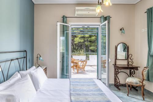 a bedroom with a bed and a door leading to a patio at Nature Grand Estate in Skopelos Town
