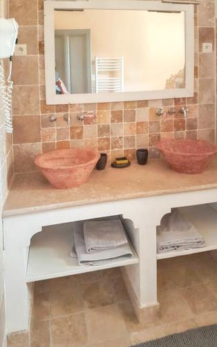 une salle de bain avec deux lavabos et un miroir dans l'établissement Maison confortable à Aubignan avec piscine partagée, à Aubignan