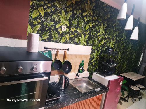 a small kitchen with a stove and a sink at Mountain View at The Edge in Cimindi