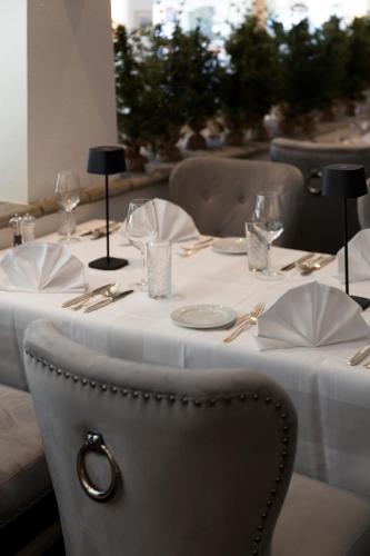 a table with a white table cloth and glasses on it at Hotel Europa Suites St Moritz in St. Moritz