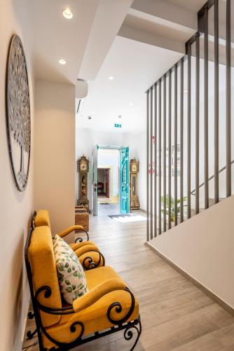 a hallway with a yellow chair and a staircase at AL-Odeceixe Verde in Odeceixe