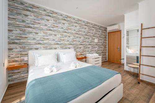 a bedroom with a large bed and a brick wall at AL-Odeceixe Verde in Odeceixe