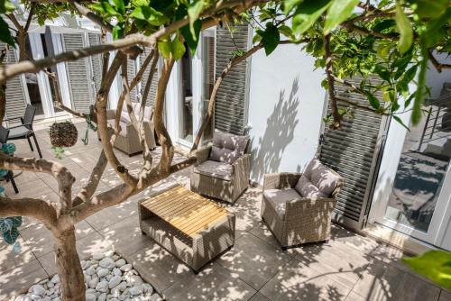 two chairs and a table on a patio with a tree at AL-Odeceixe Verde in Odeceixe