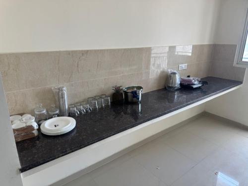 a counter with a sink and glasses on it at Omaxe Ananda in Prayagraj