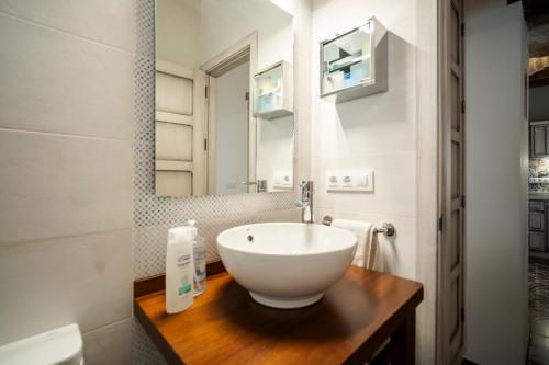 a bathroom with a bowl sink and a mirror at La Sultana de Vejer in Vejer de la Frontera