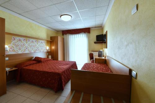 a hotel room with two beds and a window at Stella Alpina Hotel e Ristorante in Druogno