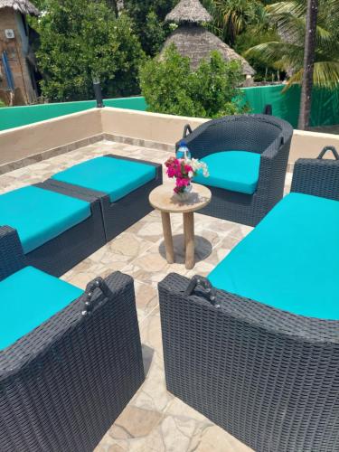 a patio with wicker chairs and a table with flowers at Princess of Zanzibar in Michamvi