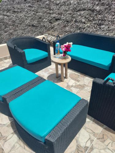 a patio with wicker chairs and a table with flowers at Princess of Zanzibar in Michamvi