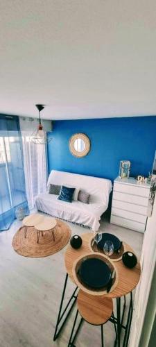 Cette chambre comprend un lit et deux tables. dans l'établissement Charmant studio avec loggia vue mer, à Saint-Hilaire-de-Riez