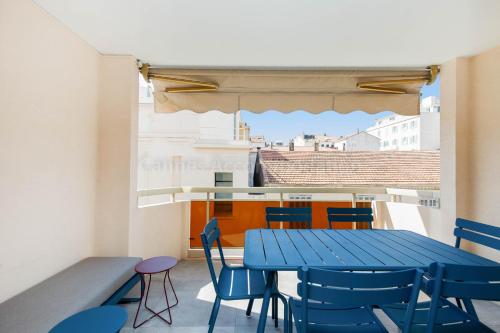 une table bleue et des chaises sur un balcon dans l'établissement Blue Bay, à Cannes