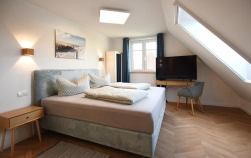a bedroom with a bed with a television and a staircase at Ferienhaus Havingblick am Yachthafen in Seedorf in Ostseebad Sellin