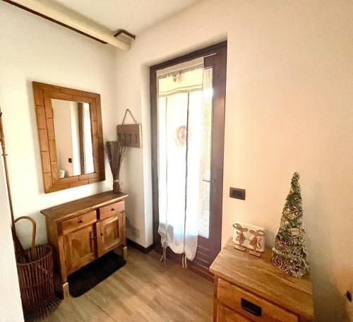 a room with a christmas tree on a dresser and a window at CASA VACANZE OLTRE IL COLLE BBQUEEN in Oltre il Colle