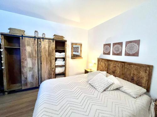 a bedroom with a bed with a wooden headboard at CASA VACANZE OLTRE IL COLLE BBQUEEN in Oltre il Colle