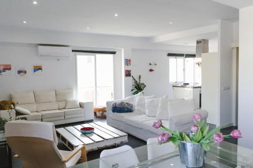 un soggiorno con mobili bianchi e tavolo in vetro di Cathedral - City Center - Free Parking - Climatized a Almería