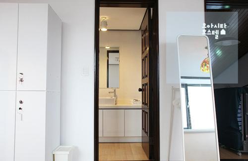 La salle de bains est pourvue d'un lavabo et d'un miroir. dans l'établissement Oasita Hostel, à Gwangju
