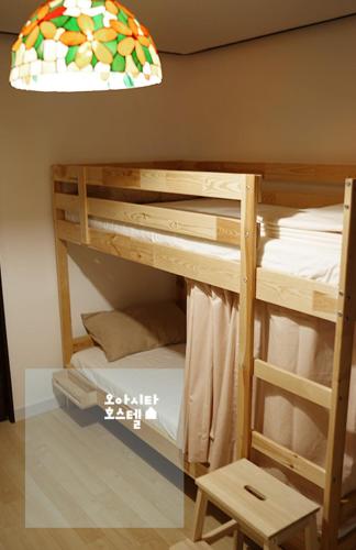 a set of bunk beds with a lamp and a chair at Oasita Hostel in Gwangju