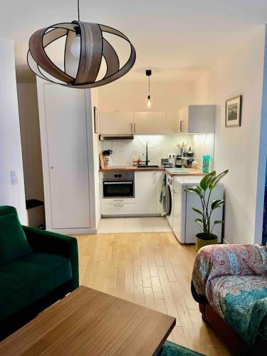 un salon avec un canapé et une cuisine dans l'établissement Paris, la plus belle ville du monde!, à Issy-les-Moulineaux
