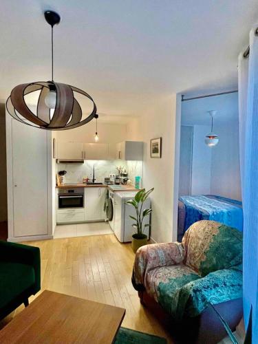 un salon avec un canapé et une cuisine dans l'établissement Paris, la plus belle ville du monde!, à Issy-les-Moulineaux