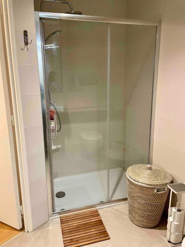 une douche avec une porte vitrée dans une salle de bain dans l'établissement Paris, la plus belle ville du monde!, à Issy-les-Moulineaux