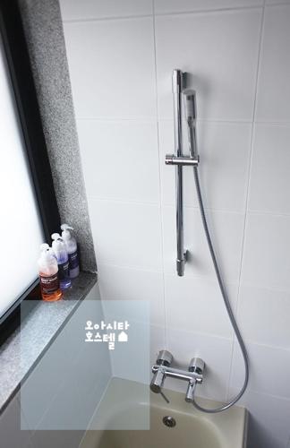 a shower in a bathroom with a sink at Oasita Hostel in Gwangju