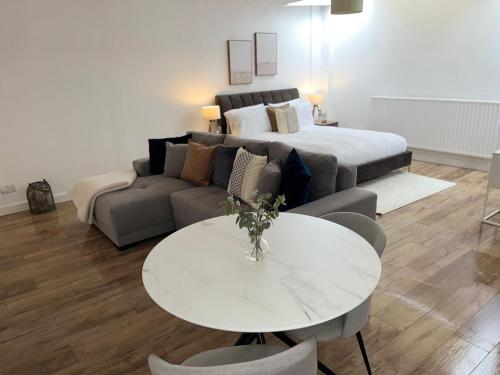 a living room with a couch and a table and a bed at Modern studio in popular South Kensington location in London