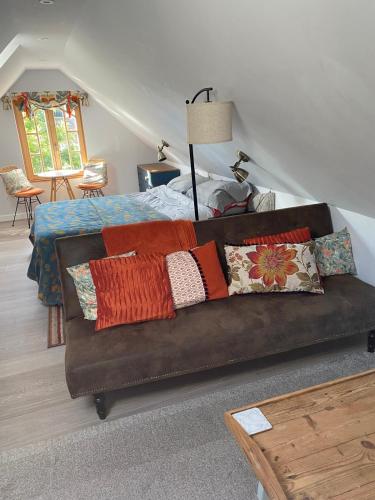 a couch with pillows on it in a bedroom at Mulleys Cottage (Bed and Breakfast) in Westleton