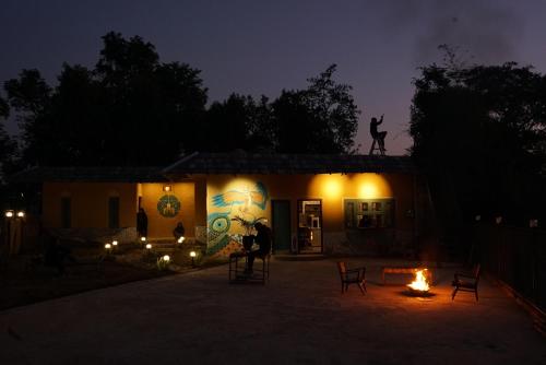 a building with a statue on the roof at night at Jaadooghar Madcap Mudhouse in Palāhu