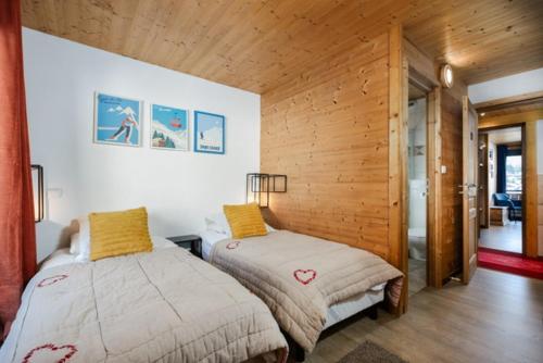 a bedroom with two beds in a room with wooden walls at Ride and Breakfast in Montriond