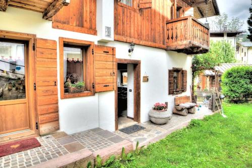 a house with wooden doors and a porch at Appartamento da Ki de Fero in Calalzo