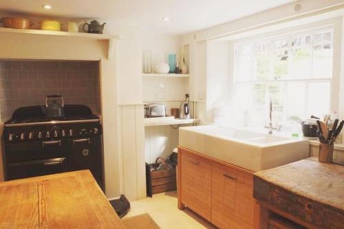 a kitchen with a stove and a sink and a window at Stanhope House in Hastings