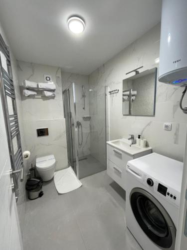 y baño blanco con lavadora. en FlyInn Residence, en Belgrado